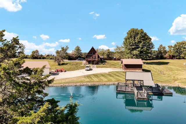 view of pool with a lawn and a water view