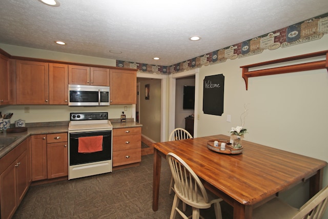 kitchen with sink, white range with electric cooktop, and a textured ceiling