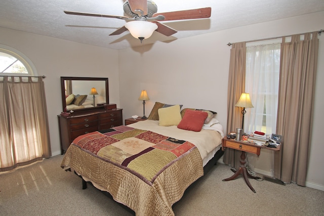 carpeted bedroom with a textured ceiling and ceiling fan