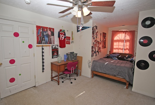 carpeted bedroom with a textured ceiling and ceiling fan