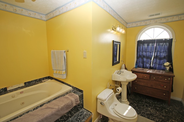 bathroom with a textured ceiling, toilet, and a bath