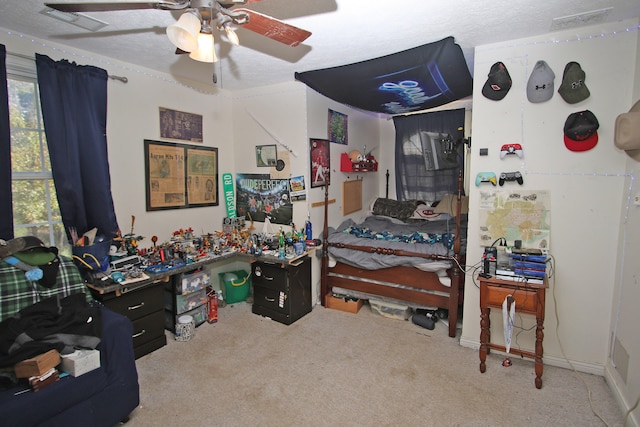 bedroom featuring ceiling fan, a textured ceiling, and carpet floors