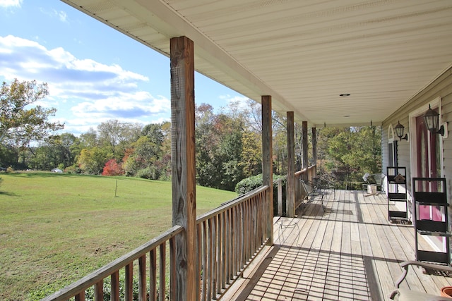 deck with covered porch and a yard