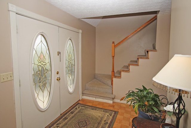 entryway with a textured ceiling and parquet floors