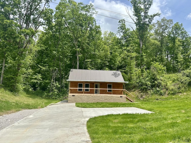 409 Freeman Branch Rd, East Bernstadt, KY 40729 - rustic home featuring covered porch, metal roof, a front lawn, crawl space, and a wooded view