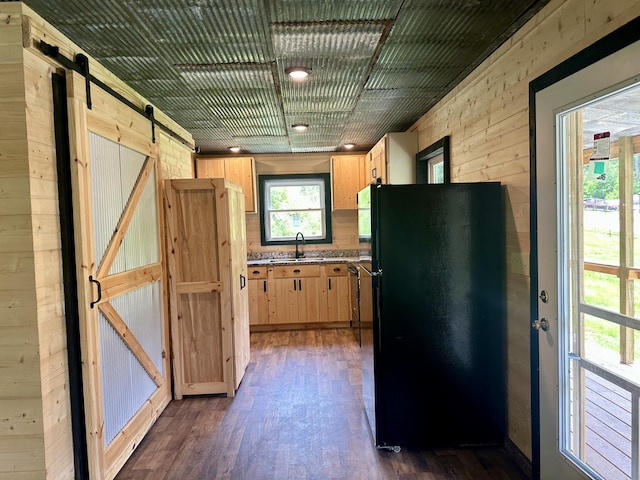 409 Freeman Branch Rd, East Bernstadt, KY 40729 - kitchen with freestanding refrigerator, a barn door, a sink, dark wood-type flooring, and wooden walls