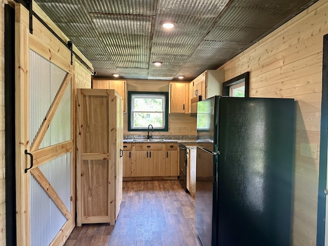 409 Freeman Branch Rd, East Bernstadt, KY 40729 - kitchen with freestanding refrigerator, a sink, light brown cabinetry, a barn door, and wooden walls