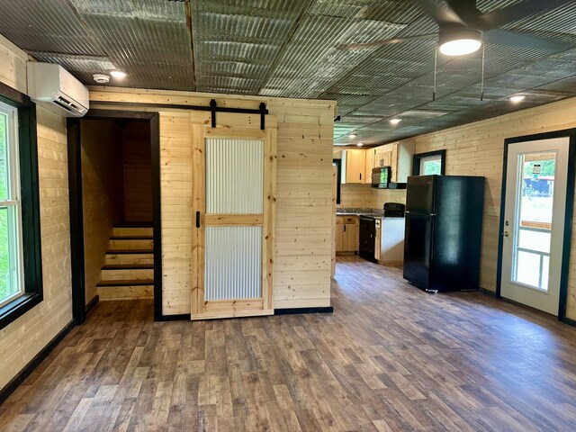 409 Freeman Branch Rd, East Bernstadt, KY 40729 - empty room with a barn door, dark wood-style floors, wooden walls, and stairs