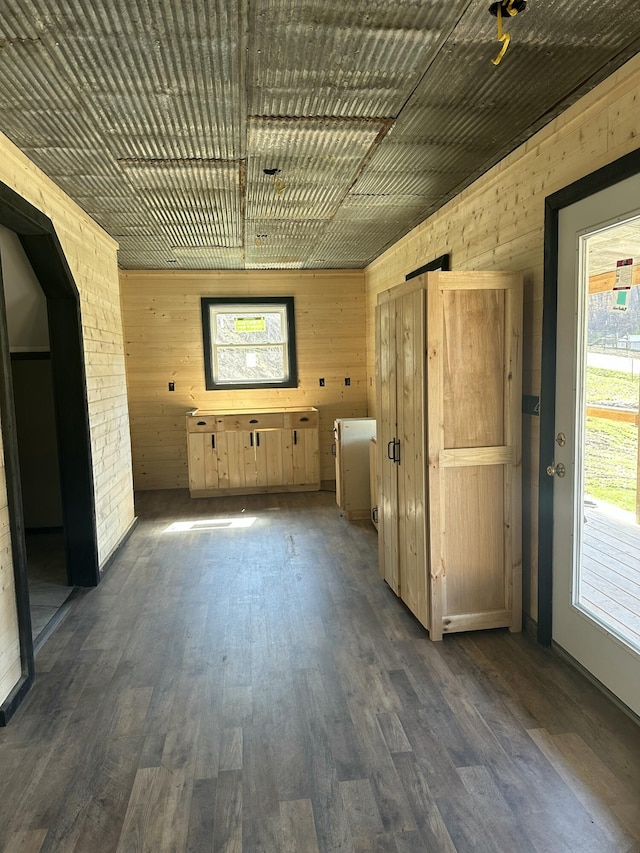 spare room featuring dark wood-style floors and wood walls