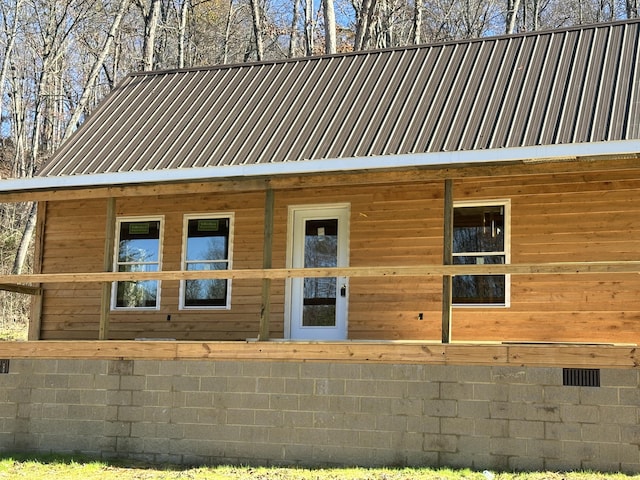 back of house with an outbuilding, metal roof, crawl space, and an exterior structure