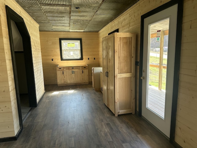 interior space featuring dark wood finished floors and wood walls