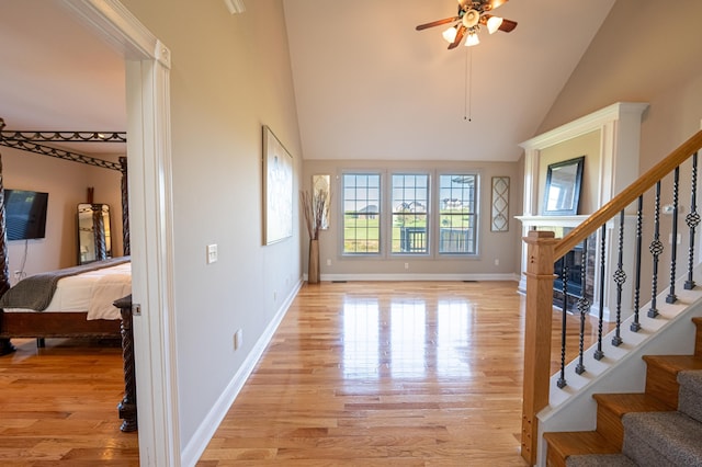 entryway featuring ceiling fan, high vaulted ceiling, and light hardwood / wood-style flooring