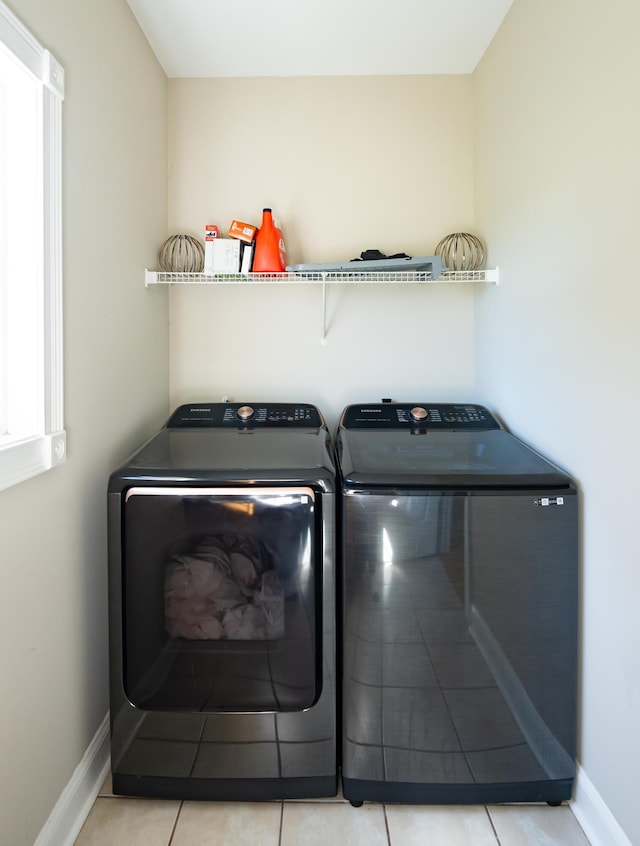 clothes washing area with light tile patterned floors and independent washer and dryer