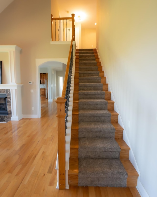 stairway featuring hardwood / wood-style flooring and a fireplace