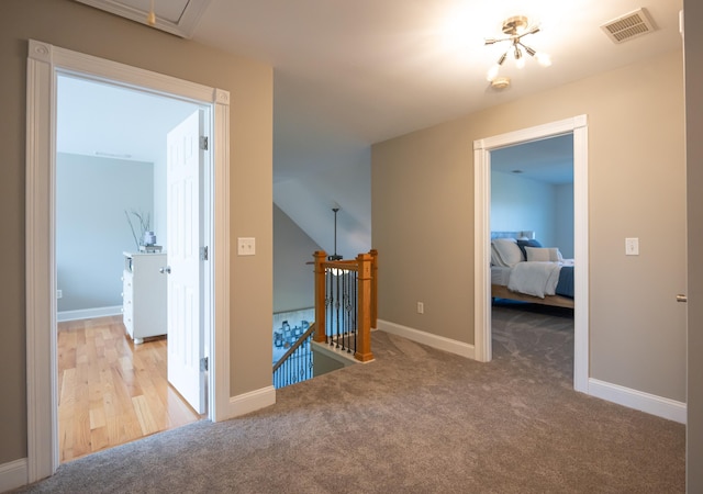 hallway featuring light colored carpet