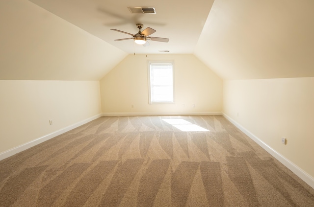 additional living space with ceiling fan, light colored carpet, and vaulted ceiling