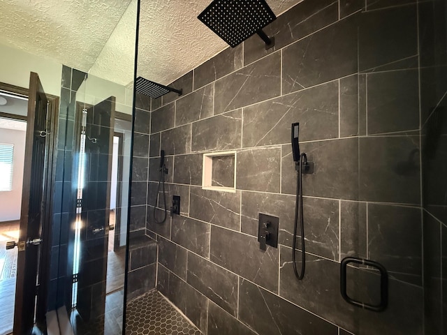 bathroom featuring an enclosed shower and a textured ceiling