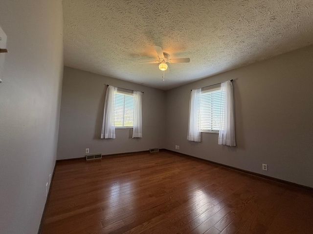 spare room featuring a textured ceiling, wood-type flooring, and ceiling fan