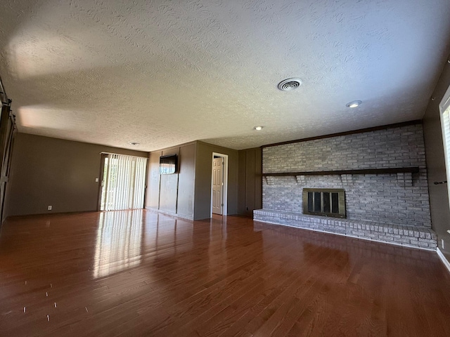 unfurnished living room featuring a textured ceiling, a fireplace, and wood-type flooring