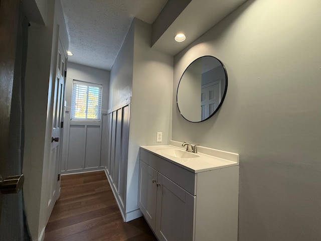 bathroom with vanity, a textured ceiling, and hardwood / wood-style flooring