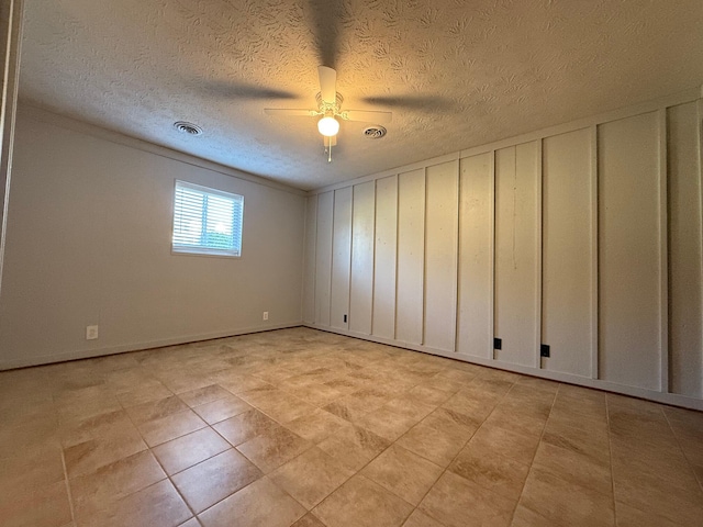 empty room featuring ceiling fan and a textured ceiling