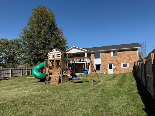 rear view of property featuring a playground and a yard