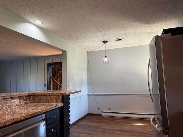 kitchen with baseboard heating, stainless steel appliances, pendant lighting, a textured ceiling, and dark hardwood / wood-style flooring