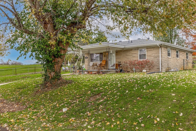 ranch-style home featuring a porch and a front lawn