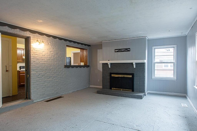 unfurnished living room featuring brick wall, a textured ceiling, and a brick fireplace