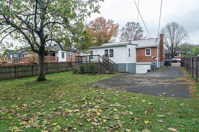 back of property with a wooden deck and a yard