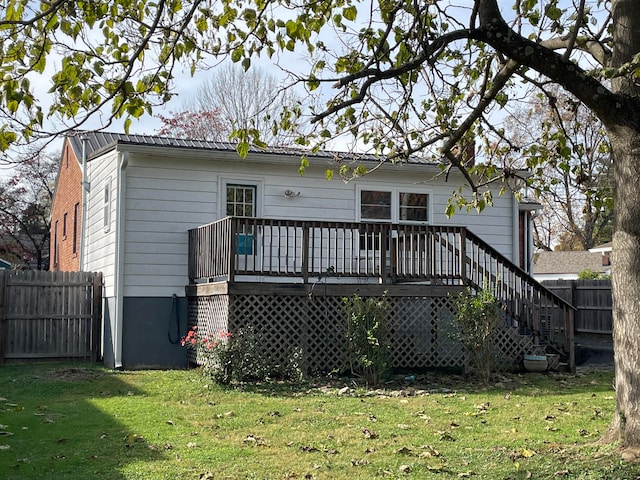 rear view of house with a wooden deck and a yard