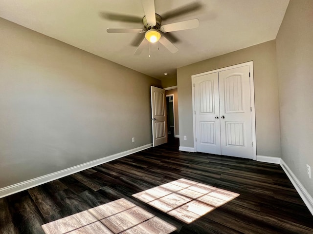 unfurnished bedroom with a closet, ceiling fan, and dark hardwood / wood-style flooring