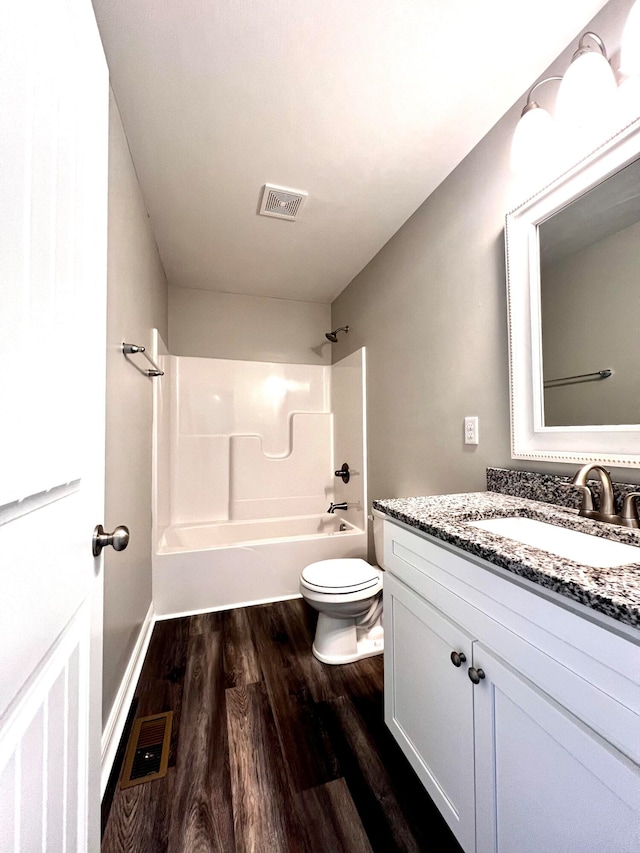 full bathroom featuring toilet, hardwood / wood-style floors, vanity, and bathing tub / shower combination