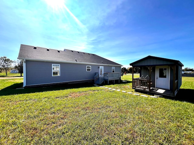 rear view of property featuring a yard and a deck