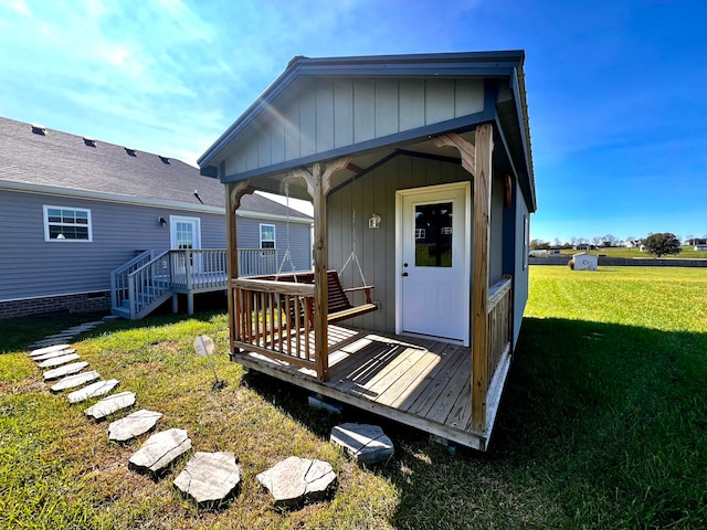 back of house with a deck and a lawn