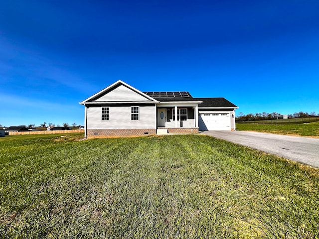 view of front facade with solar panels, a front yard, and a garage