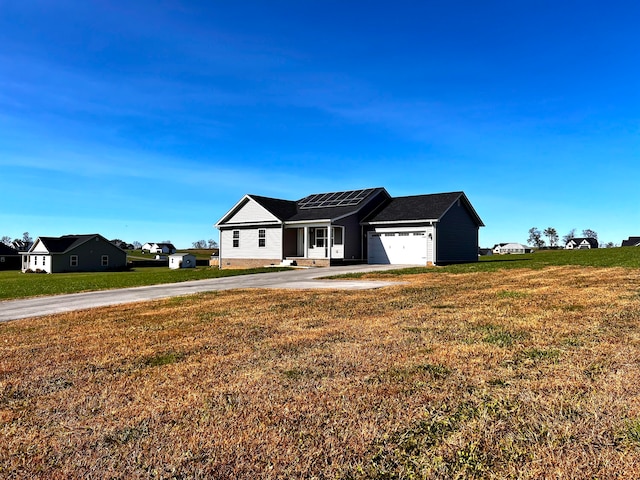 ranch-style house with a front yard, a garage, and solar panels