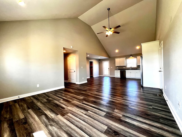 unfurnished living room with ceiling fan, high vaulted ceiling, sink, and dark hardwood / wood-style flooring