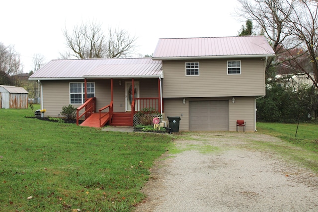 view of front of house featuring covered porch, a garage, and a front lawn