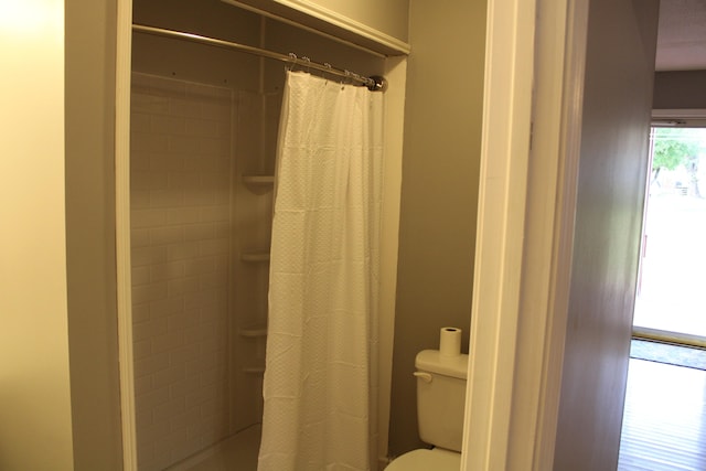 bathroom featuring a shower with curtain and toilet