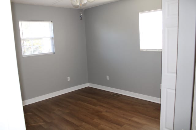 spare room featuring ceiling fan and dark wood-type flooring