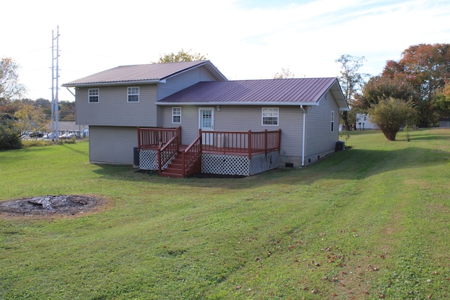 rear view of house with a wooden deck and a yard