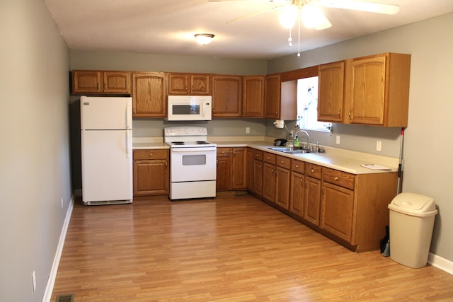 kitchen with light wood-type flooring, white appliances, ceiling fan, and sink