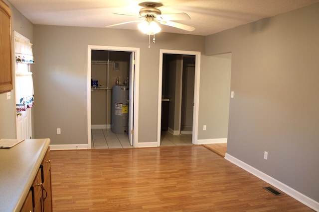 interior space featuring water heater, ceiling fan, and light hardwood / wood-style floors