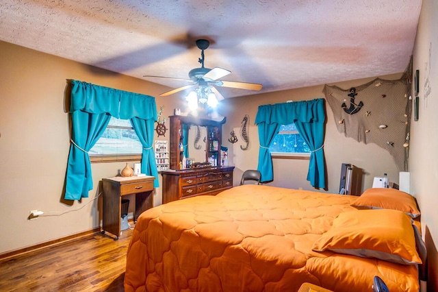 bedroom featuring ceiling fan, hardwood / wood-style flooring, and a textured ceiling