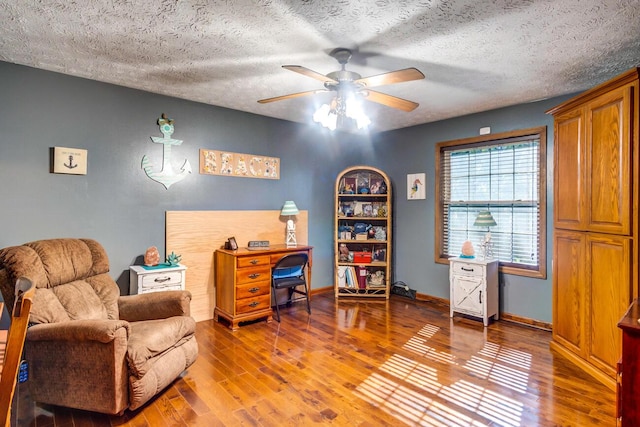 home office featuring hardwood / wood-style flooring, ceiling fan, and a textured ceiling