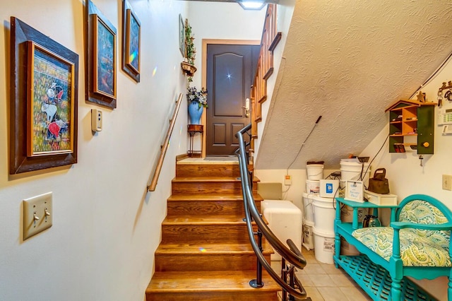 stairs with tile patterned floors and a textured ceiling