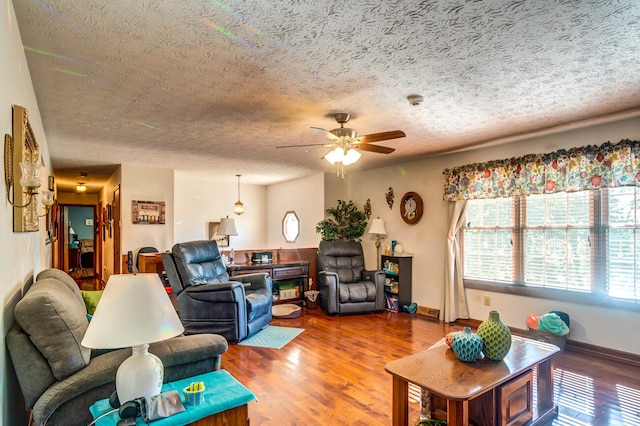 living room featuring a textured ceiling, hardwood / wood-style flooring, and ceiling fan