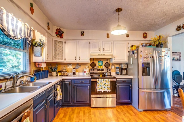 kitchen with stainless steel appliances, sink, white cabinets, and light hardwood / wood-style flooring