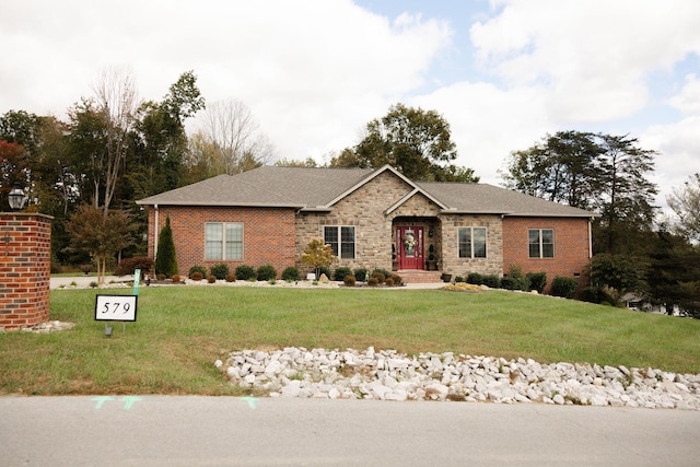 single story home featuring stone siding, brick siding, and a front yard